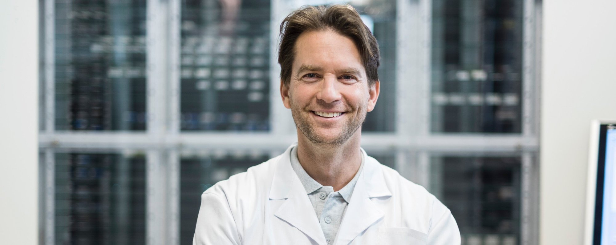 Header_Image-Picture-Smiling-Man-Wearing-a-Lab-Coat-20210630-GLO-EN-1