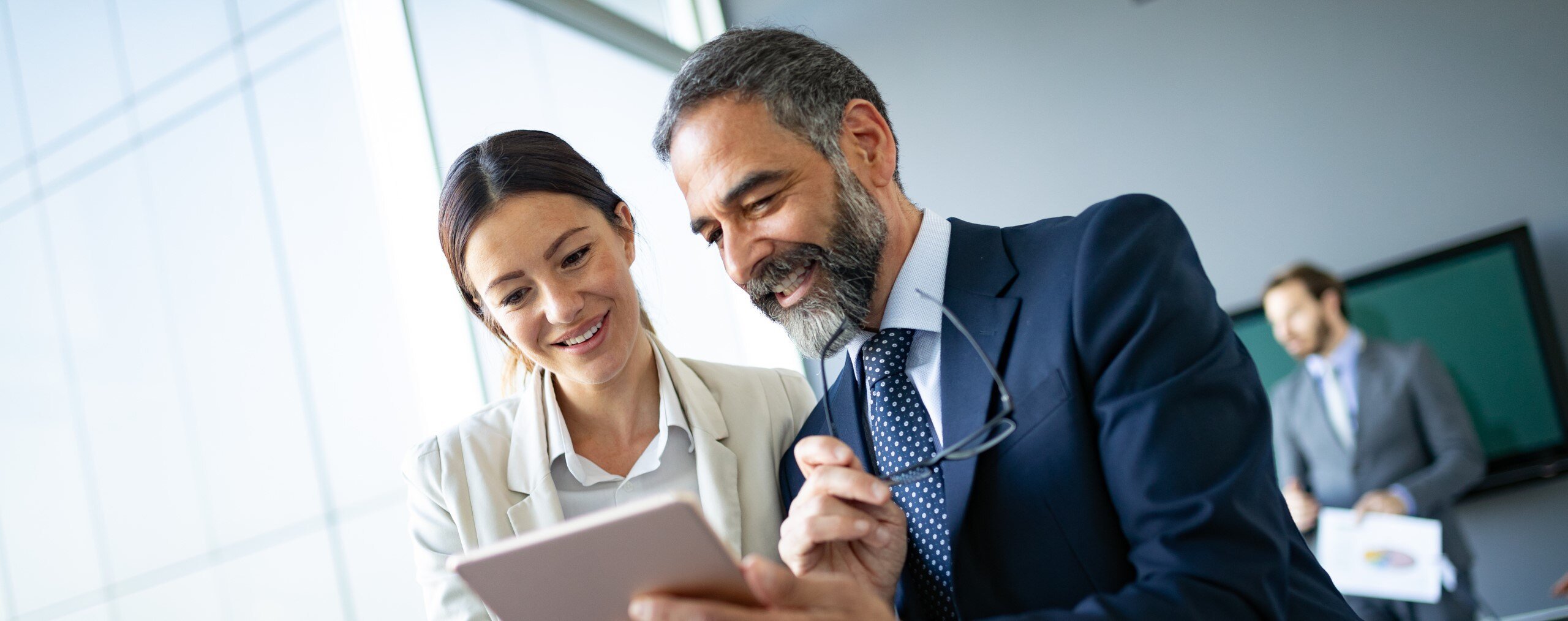 Header_Image-picture-Happy-business-colleagues-in- modern-office-using-tablet-2-20220414-GLO-EN-1